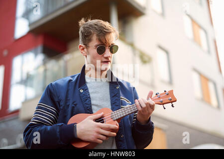 Young man on playing ukulele Stock Photo