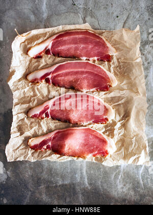 Bacon slices on brown paper, elevated view Stock Photo