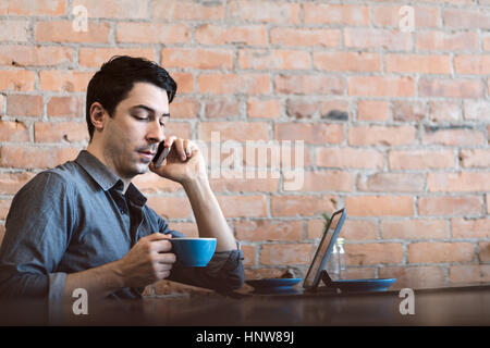 Man using mobile phone at cafe Stock Photo