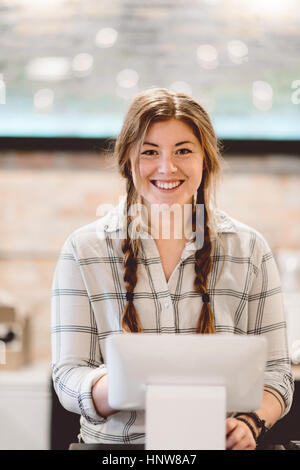 Cashier behind cash register in cafe Stock Photo