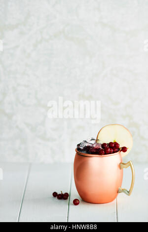 Non-alcoholic cocktail in copper mug with berries and apple slice Stock Photo