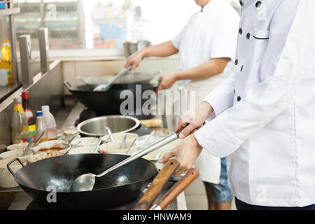 Group of chefs in hotel or restaurant kitchen busy cooking Stock Photo