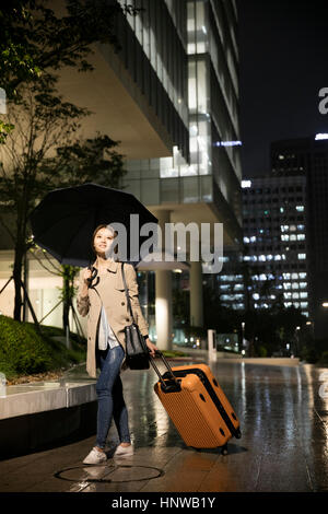 Woman with umbrella and carrier Stock Photo