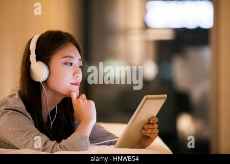Young woman with headsets using tablet Stock Photo