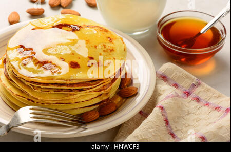 Pancakes with honey and almond on a white backgraund Stock Photo