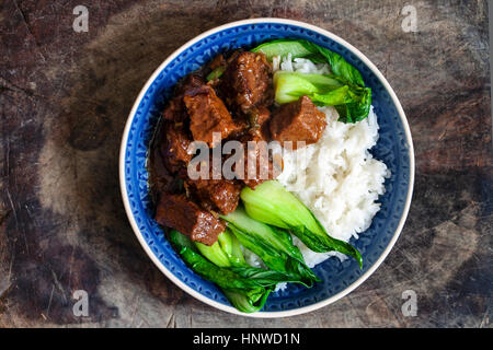 Spicy Chinese style braised beef with rice and pak choi Stock Photo