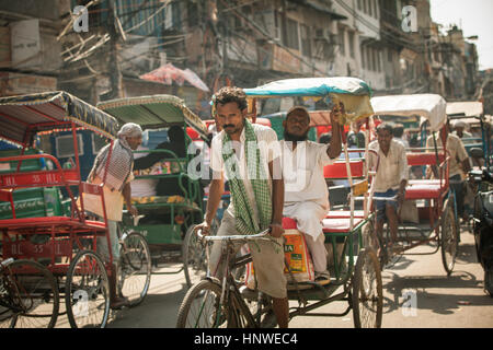 Delhi, India - September 18, 2014: Cycle rickshaw riding the vehicle under the heat on the street of Old Delhi, India on September 18, 2014. Stock Photo