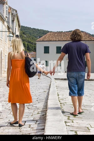 Model release, Paerchen spaziert Hand in Hand ueber den Hauptplatz von Hvar, Dalmatien, Kroatien - couple in Hvar, Croatia Stock Photo