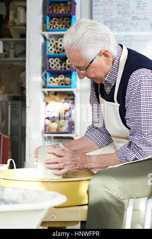 Senior Man Working At Pottery Wheel In Studio Stock Photo