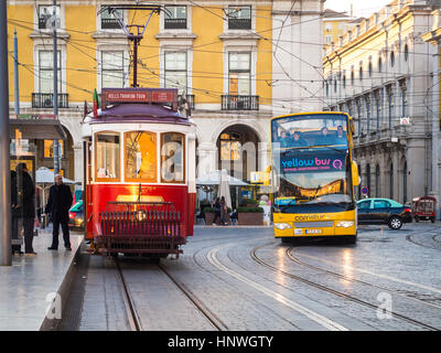 LISBON, PORTUGAL - JANUARY 10, 2017: Transport in Lisbon: typical old tram and a touristic bus on the Praca do Comercio (Commerce Square). Stock Photo