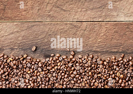 Overhead shot looking down on a flatlay image of coffee beans over a rustic wood table top background with copy space. Stock Photo
