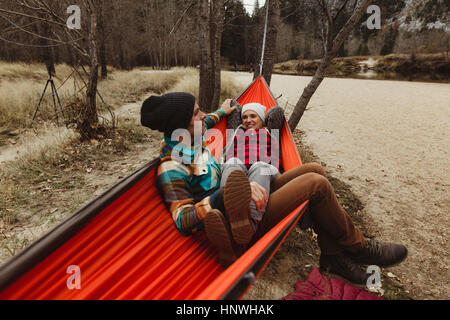 Couple reclining in red hammock at Yosemite National Park, California, USA Stock Photo