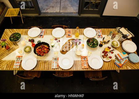 Dining table setting for six with variety of dishes Stock Photo
