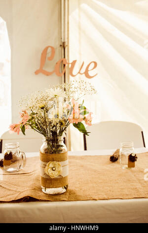 Wedding table with rustic floral display and 'love' sign Stock Photo