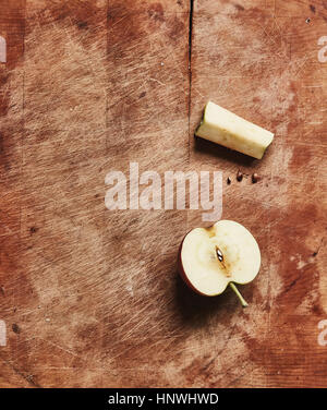 Overhead view of fresh halved apple and apple core on wooden cutting board Stock Photo