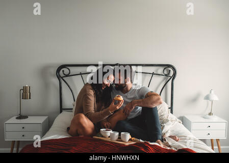 Romantic couple eating breakfast in bed Stock Photo