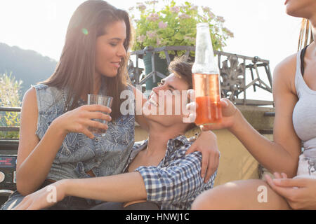 Young couple flirting at roof terrace party Stock Photo