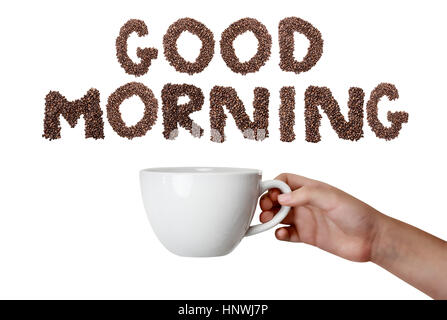 Isolated woman's hand holding coffee cup over white background with phrase Good Morning spelled out in coffee beans. Stock Photo