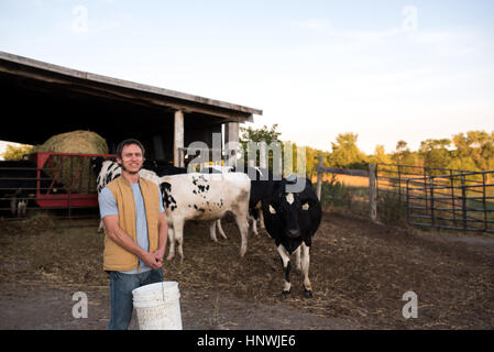 Portrait of farmer on farm, holding animal feed Stock Photo