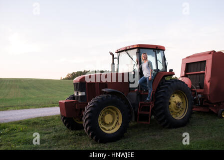 Portrait of woman standing on tractor Stock Photo