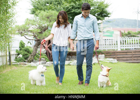 Young couple walking pet dogs Stock Photo