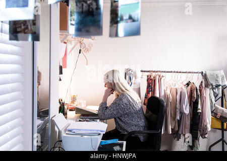 Female university student studying in the bedroom in her shared student house Stock Photo