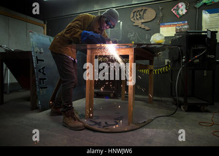 Male metalsmith plasma cutting metal at workbench Stock Photo