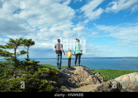 Rear view of family holding hands looking away at view of sea, Bar Harbor, Maine Stock Photo