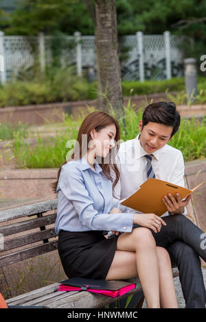 Young smiling business people sharing file Stock Photo