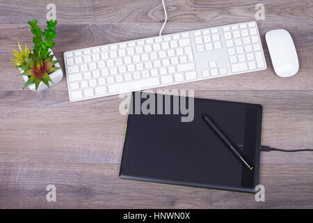 Wooden desk with a keyboard ,  mouse and pen tablet  from above Stock Photo