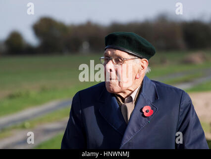 An old man wearing a beret and poppy attends an outdoor event to mark Remembrance day Stock Photo