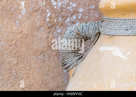 Water urn handle.  Carry handle of an earthenware water jug.  Handle covered in natural twine Stock Photo