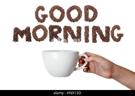 Isolated woman's hand holding coffee cup over white background with phrase Good Morning spelled out in coffee beans. Stock Photo