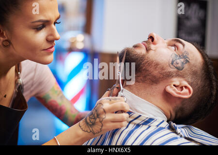 Hairdresser trimming customer's beard Stock Photo