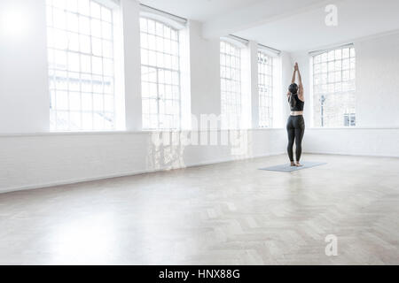 Rear view of woman in dance studio stretching Stock Photo