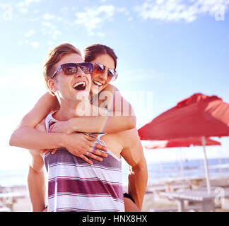 Man giving smiling woman piggyback