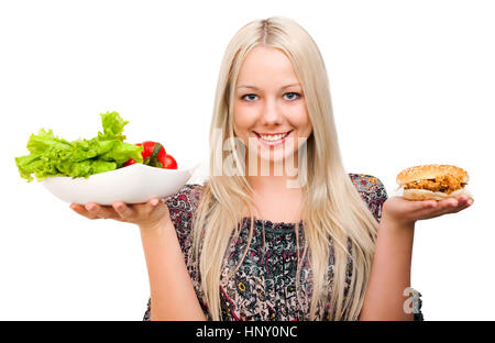 woman choosing what to eat, vegetables or burger, isolated against white background Stock Photo