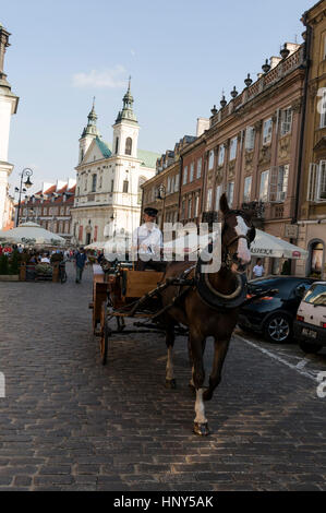 A horse driven carriage carrying tourists on a street sight-seeing tour on the main thoroughfare, Freta  Nowomiejska  in Warsaw Old Town in Warsaw,Pol Stock Photo