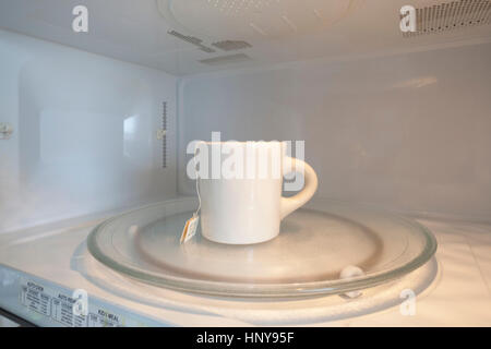 Tea cup in microwave Stock Photo