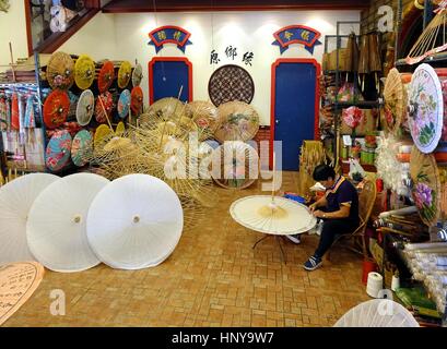 KAOHSIUNG, TAIWAN -- JULY 24, 2016: A female craftsperson makes oil-paper umbrellas, which is a traditional art and craft product by the Chinese Hakka Stock Photo