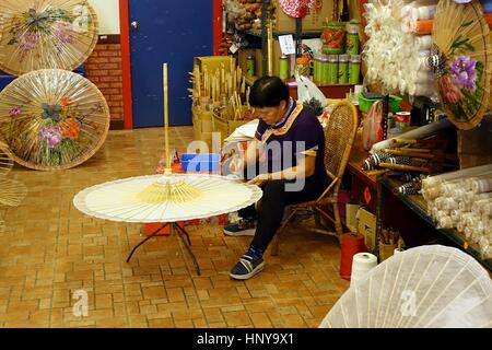 KAOHSIUNG, TAIWAN -- JULY 24, 2016: A female craftsperson makes oil-paper umbrellas, which is a traditional art and craft product by the Chinese Hakka Stock Photo