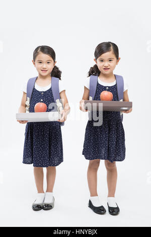 Smiling twin girls with backpacks Stock Photo