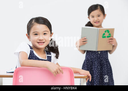 Smiling twin girls with books Stock Photo