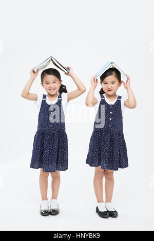 Smiling twin girls with books Stock Photo