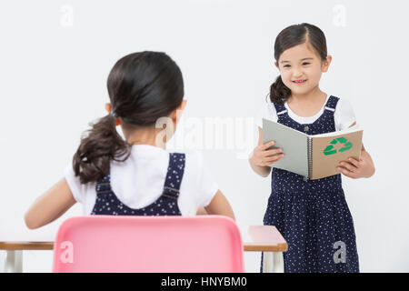 Smiling twin girls with books Stock Photo