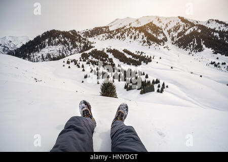 Hiker legs in tracking boots at amazing snowy mountains view Stock Photo