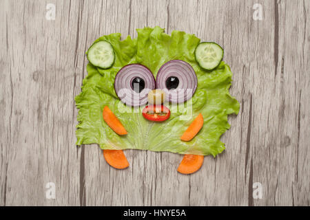 Bear made of green vegetables on wooden plank Stock Photo