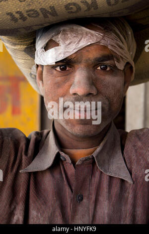 Nepali labor man carrying a sack of cement Stock Photo