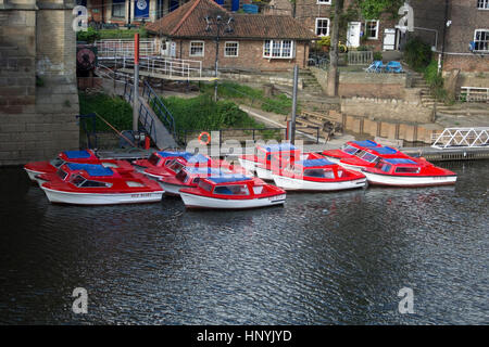 Flotilla of Self Drive Motor Boats River Ouse York thirteen small red white and blue self drive Red Boats Yorkboats motor boats cruising sailing sight Stock Photo