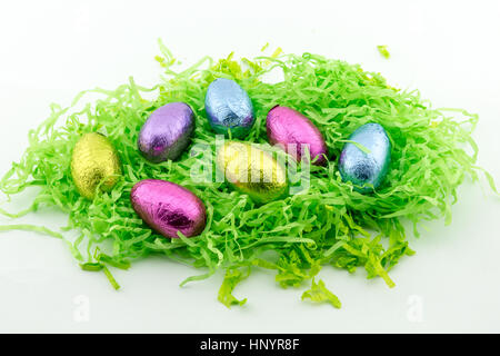 Easter Eggs on green shredded paper with yellow chickens Stock Photo